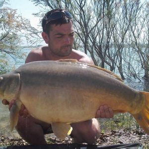 Man in glasses holding carp