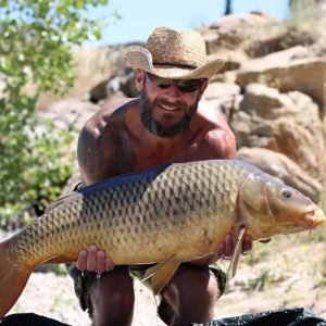 Man with hat holding carp